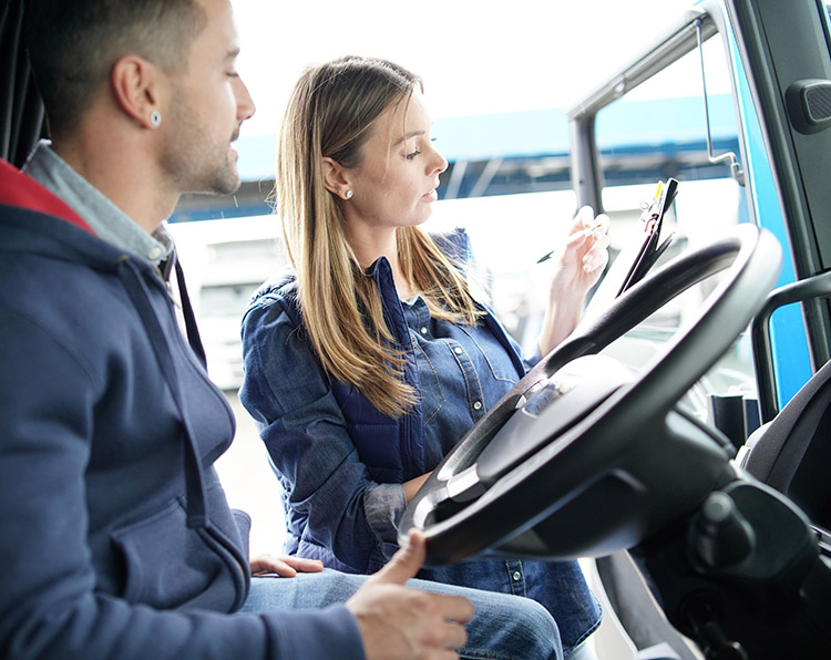 A shipping clerk reviewing paperwork with a truck driver
