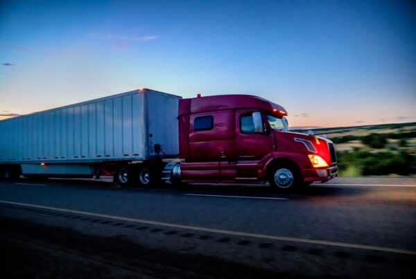 A red tractor-trailer hauling a load amid the uncertain 2024 freight market.