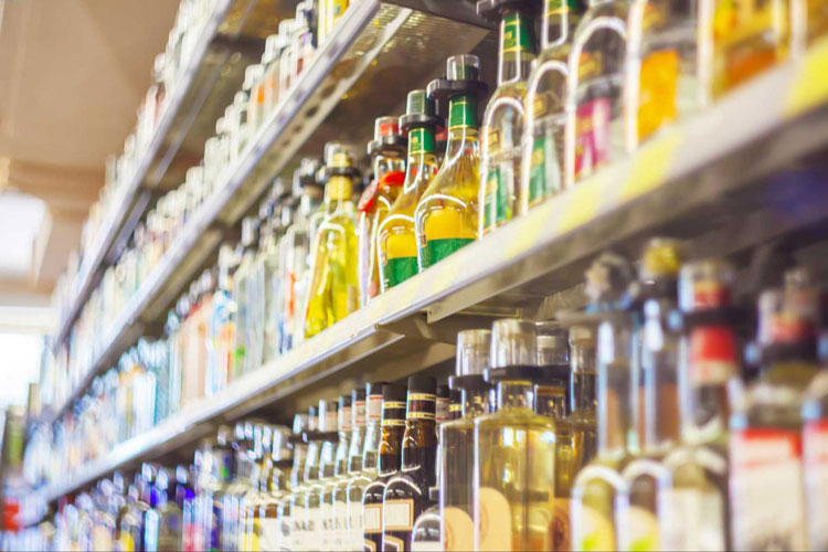 A liquor store with its store shelf fully stocked with various spirits.